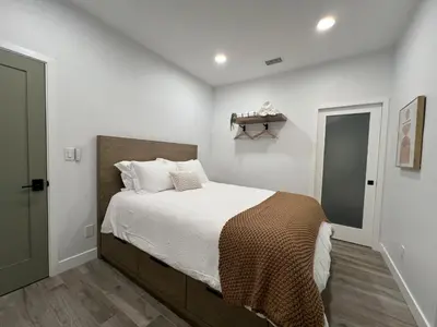 a bedroom with a large bed with white walls at Castaway Cay near Disney with Hot Tub and Fire Pit in Anaheim