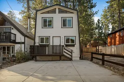 a white house with a porch and a fence at Hearthmoon Haven in Big Bear Lake