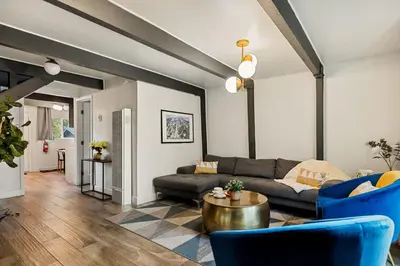 a living room with a black couch and blue chairs at Hearthmoon Haven in Big Bear Lake