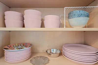 a shelf with plates and bowls in a cabinet at Remodeled 1BR LA Apartment with full kitchen in Los Angeles