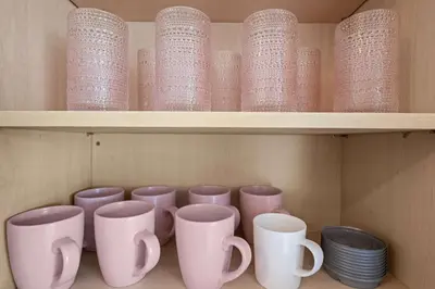 a row of cups and plates on a shelf at Remodeled 1BR LA Apartment with full kitchen in Los Angeles