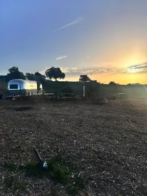 a field with a camper in the sunset at Zaromelranch