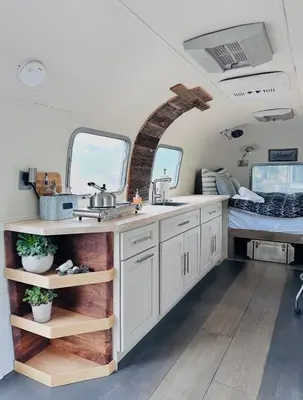 a kitchen in an rv with a sink and a bed at Zaromelranch