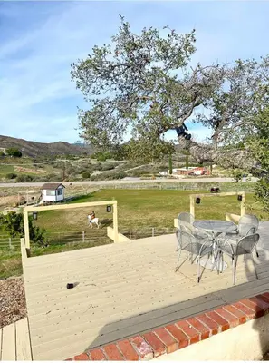 a patio with a table and chairs and a field at Zaromelranch