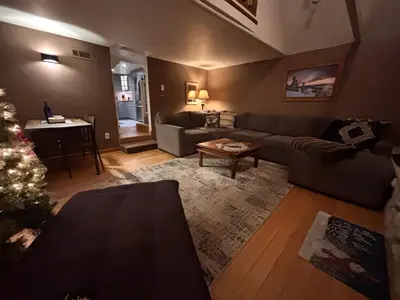 a living room with a couch and a christmas tree at Lakeview Location Hot tub Tesla Charger tree house in Big Bear Lake