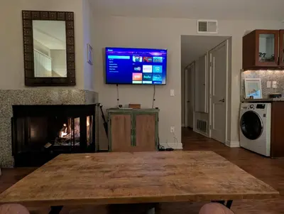 a living room with a table and a tv on the wall at ENSUITE MASTER BEDROOM IN WEST HOLLYWOOD - super host in Los Angeles