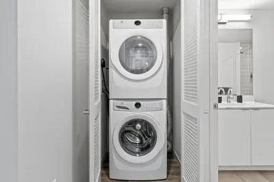 a white washer and dryer in a bathroom at Nautical Knees Water View Pool, Jacuzzi and Gym in Los Angeles