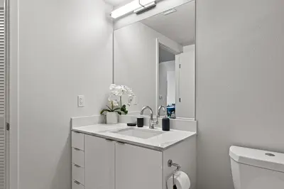 a white bathroom with a sink and a mirror at Nautical Knees Water View Pool, Jacuzzi and Gym in Los Angeles