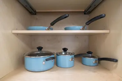 four pots and pans on a shelf in a kitchen at LuxuryCondo DTAlhambra Near Starbucks Free2Parking in Alhambra