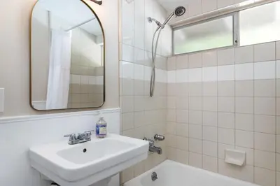 a white bathroom with a sink and a mirror at SoCal Retreat with Pool and Spacious Backyard in Canoga Park