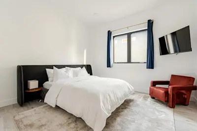 a bedroom with a bed and a tv and a chair at Abracadabra Ultra Luxury Private Residence in Los Angeles