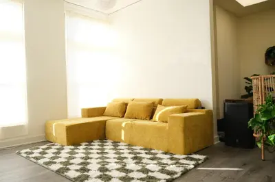 a yellow couch in a living room with a rug at Paradise Knowhere in Los Angeles
