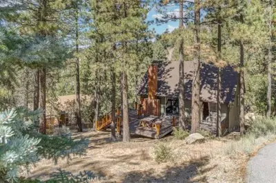 a house in the middle of the woods at Pet Friendly 3BR Pine Mountain Club Cabin with King Bed and Pool Access in Pine Mountain Club