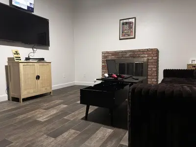 a living room with a fireplace and a tv at Brick & Breeze in Bakersfield