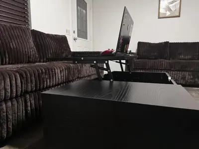 a living room with a couch and a laptop on a table at Brick & Breeze in Bakersfield