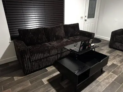 a living room with a brown couch and a coffee table at Brick & Breeze in Bakersfield