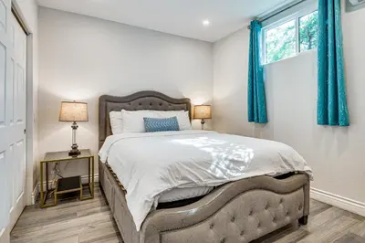 a bedroom with a large bed with blue curtains at Explore Shops, Eats and Entertainment! Pasadena Apt in Pasadena