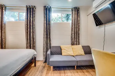 a bedroom with a couch and a tv and windows at 4 Mi to Old Pasadena! Well-Appointed Studio Stay in Pasadena