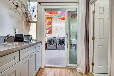 a kitchen with a door leading to a washer and dryer at 4 Mi to Old Pasadena! Well-Appointed Studio Stay in Pasadena