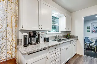 a kitchen with white cabinets and a sink at Peacock House Sanctuary 4 Mi to Old Pasadena! in Pasadena