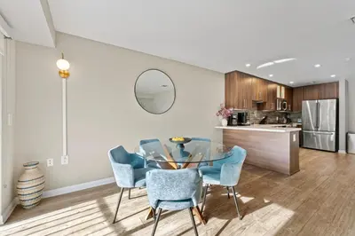 a kitchen and dining room with a glass table and chairs at Vertical Blue Bi-Level Sanctuary with Pacific Vistas in Los Angeles
