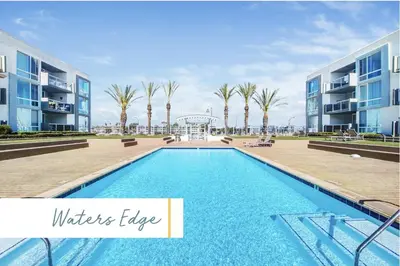 a swimming pool in front of two apartment buildings at The Glass Anchor - 2 Bed Front-Row Marina Suite in Los Angeles