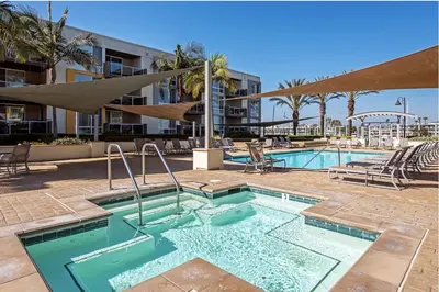 a pool at a resort with chairs and a umbrella at The Glass Anchor - 2 Bed Front-Row Marina Suite in Los Angeles