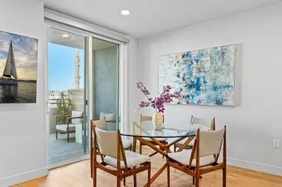 a dining room with a glass table and chairs at Urban Tide - A Designer Escape Overlooking the Docks in Los Angeles