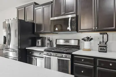 a kitchen with stainless steel appliances and wooden cabinets at Serenity House in Bakersfield