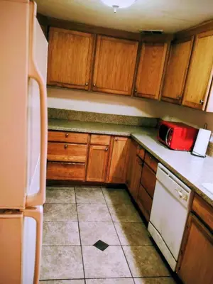 a kitchen with wooden cabinets and a red microwave at The Joshua House in Boron
