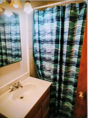 a bathroom with a sink and a shower curtain at The Joshua House in Boron