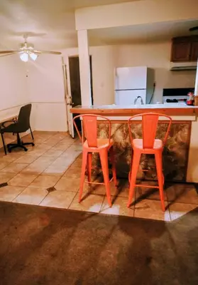 a kitchen with two orange chairs and a counter at The Joshua House in Boron