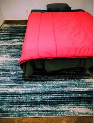 a red bed sitting on top of a rug at The Joshua House in Boron