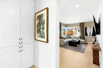 a living room with white walls and a white couch at The Drift Manhattan Beach - steps to the ocean in Manhattan Beach