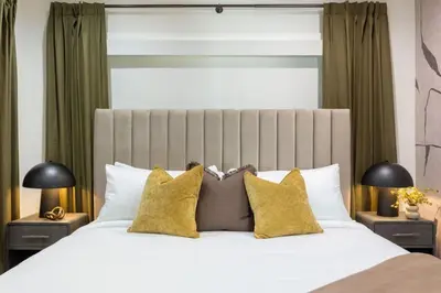 a bedroom with a large white bed with yellow pillows at The Drift Manhattan Beach - steps to the ocean in Manhattan Beach