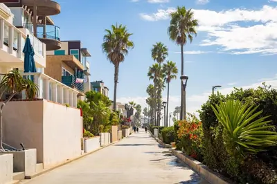 a sidewalk lined with palm trees and buildings at The Drift Manhattan Beach - steps to the ocean in Manhattan Beach