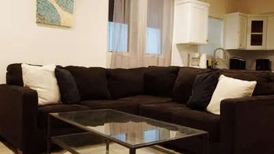 a living room with a brown couch and a glass table at Paradise in LA near LAX and SoFi Stadium in Los Angeles