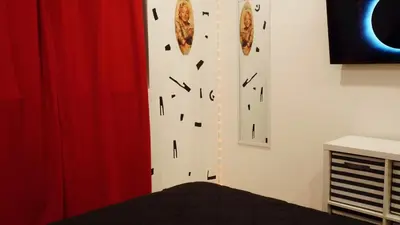 a bedroom with a wall with clocks on it at Paradise in LA near LAX and SoFi Stadium in Los Angeles
