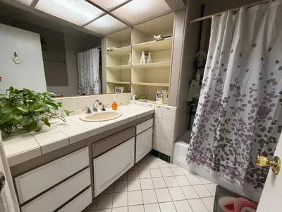 a bathroom with a sink and a shower curtain at Citrus Loft Room B - Quiet and Convenience Female Only in Covina