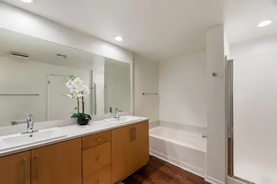 a bathroom with two sinks and a tub and a mirror at The Zenith Penthouse - Ocean Panoramas & Salt Air in Los Angeles