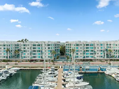 a group of boats in a marina with a large building at The Zenith Penthouse - Ocean Panoramas & Salt Air in Los Angeles