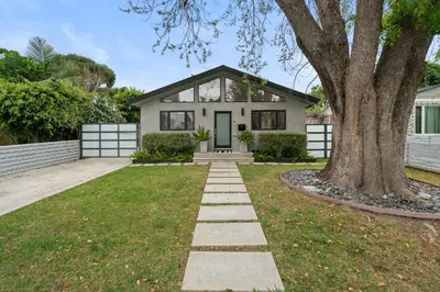 a house with a tree in the front yard at New Listing West LA Urban Oasis by Colby & Conrad in Los Angeles