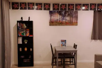 a dining room with a table and a book shelf at Themed Townhouse Retreat Near LAX and Sofi in Los Angeles