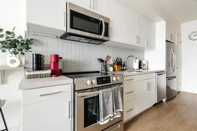 a kitchen with white cabinets and a stove top oven at Platinum Space in WeHo in Los Angeles