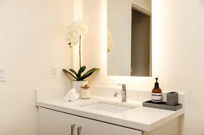 a white bathroom with a sink and a mirror at Platinum Space in WeHo in Los Angeles