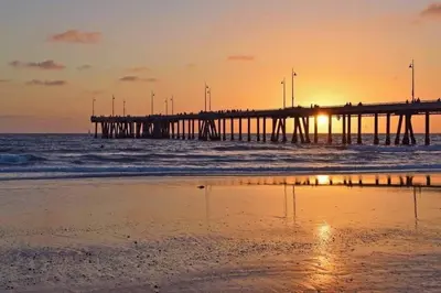 a pier in the ocean at sunset with a beach at Ocean's Edge 2BR Penthouse - Infinite Blue Views in Los Angeles
