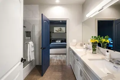 a bathroom with two sinks and a blue door at Sherman Oaks Home w Pool, Spa and Outdoor Kitchen in Los Angeles