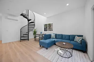 a living room with a blue couch and a spiral staircase at New Listing Iconic Venice Living by Colby & Conrad in Los Angeles