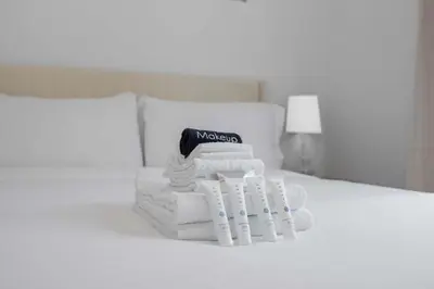 a pile of towels sitting on a bed at New Listing Iconic Venice Living by Colby & Conrad in Los Angeles