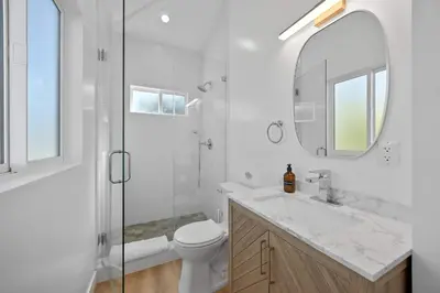 a bathroom with a toilet and a sink and a mirror at New Listing Iconic Venice Living by Colby & Conrad in Los Angeles